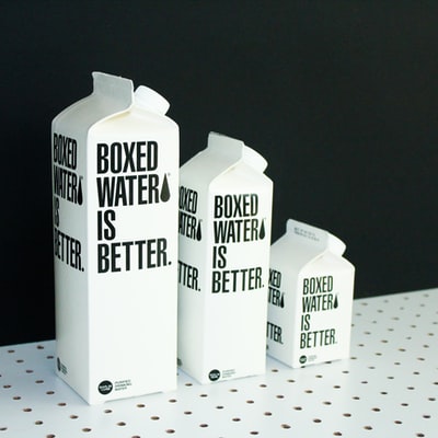 三个不同大小的盒装水纸箱在黑色和白色背景
